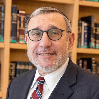 Headshot of Moshe Sokol in library setting.